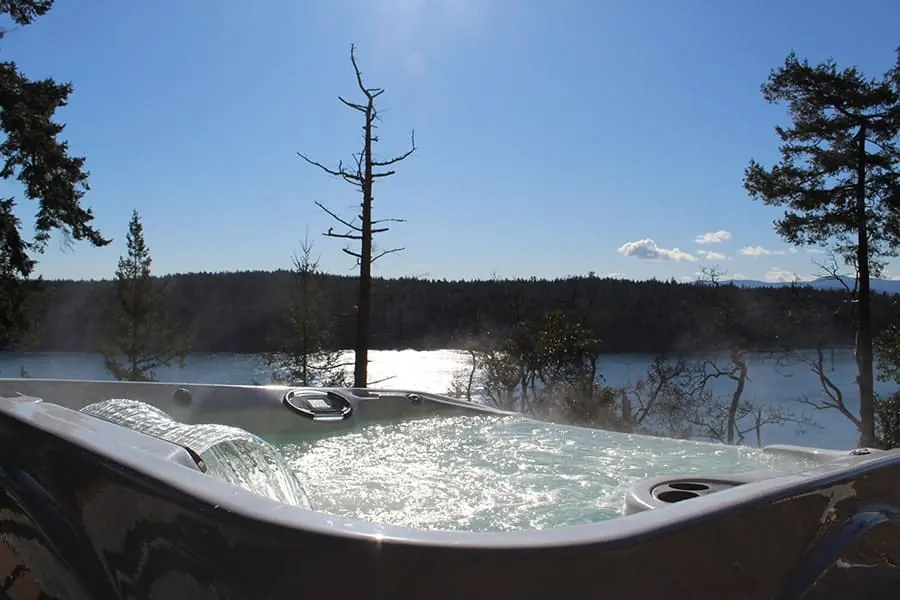 A hot tub on a terrace looking out over open country toward distant high ground at dusk